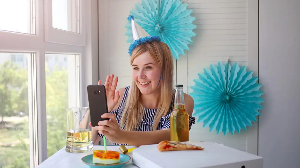 Woman taking selfie wearing birthday hat
