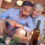 Man blowing out birthday candles on cake