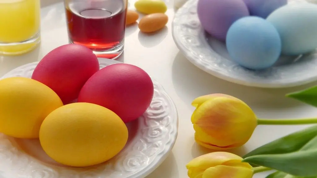 Easter eggs and tulips on table