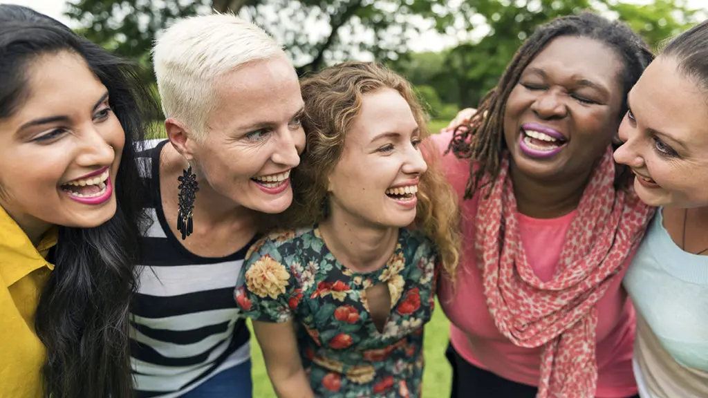 Five women laughing together