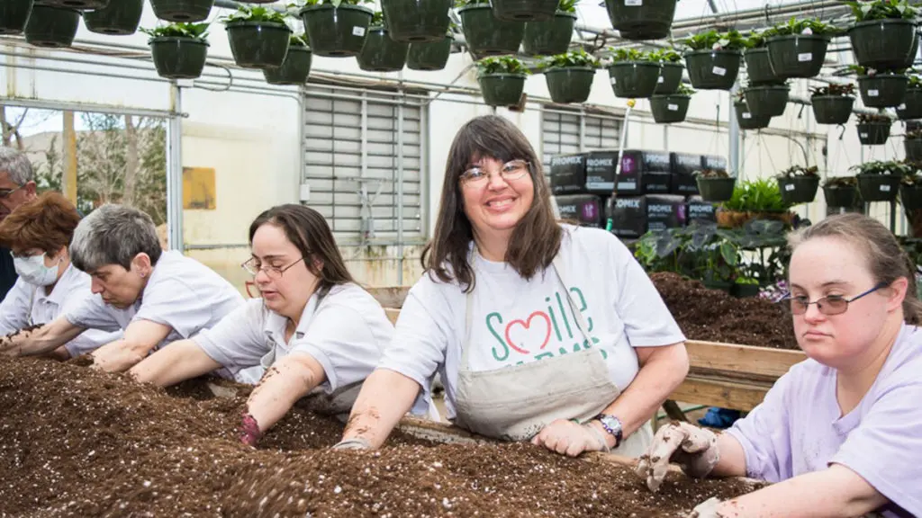 Smile Farms Famers work on a planting bed