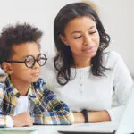 Two kids using a laptop