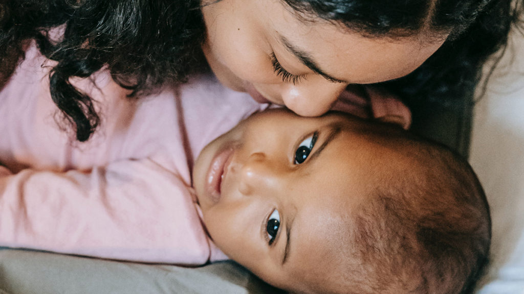 Una madre besando a su bebé, otro efecto Mommy Brain.  Una forma en que la naturaleza cambia el cerebro de las madres es haciendo que los bebés se vuelvan adictos.
