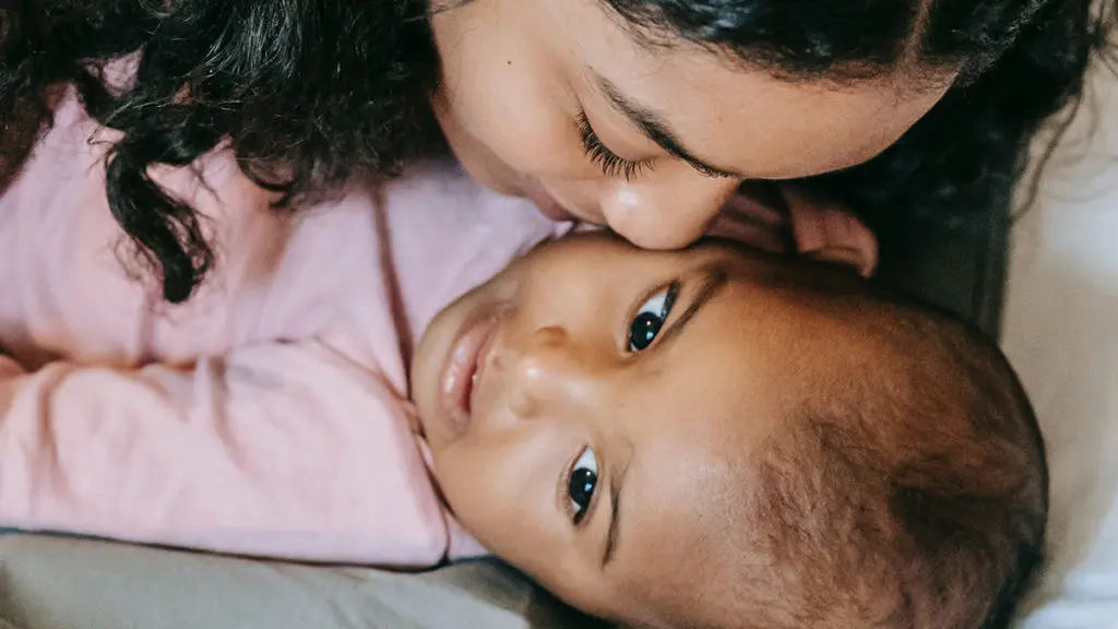 Mom kissing baby