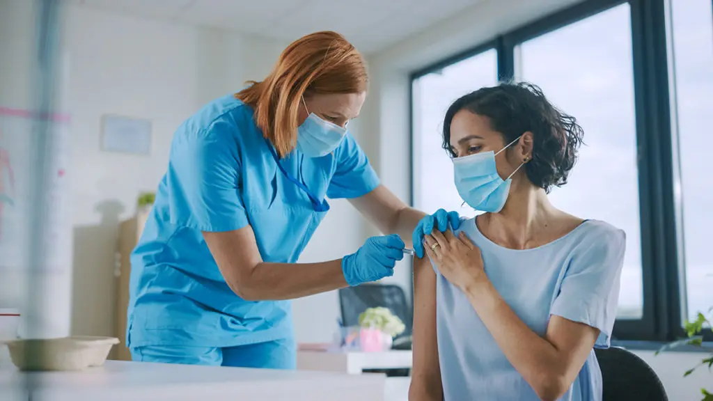 Nurse giving patient a shot