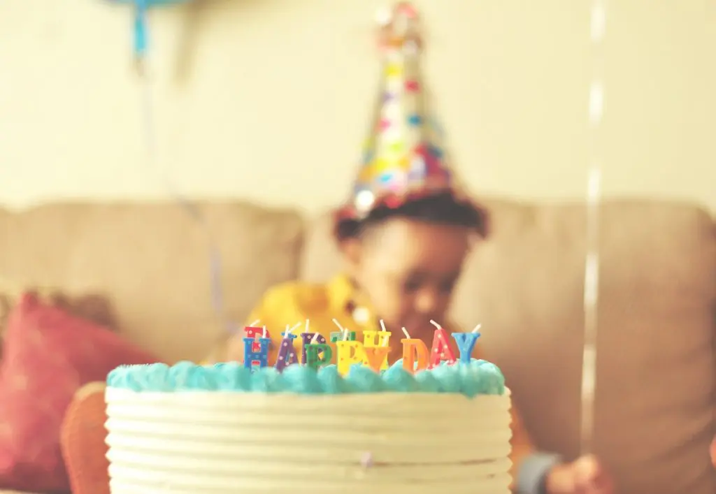 Blowing out candles is one of the most popular birthday traditions. In this image, a young boy gets ready to make his wish.