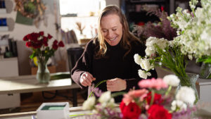 A photo of local florist Patti Fowler inspecting flowers