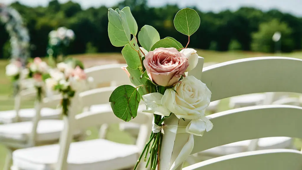 Wedding flower symbolism with Garden roses on wedding chairs