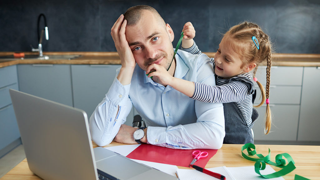 This is an image of daddy brain with a little girl distracting her father while working from home. 