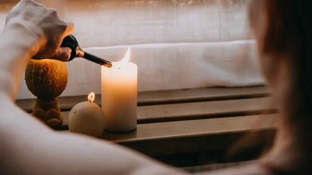 Photo of woman lighting a candle in relaxing setting