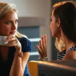 Photo of two women talking while drinking coffee