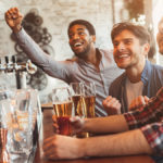 Men at bar watching TV