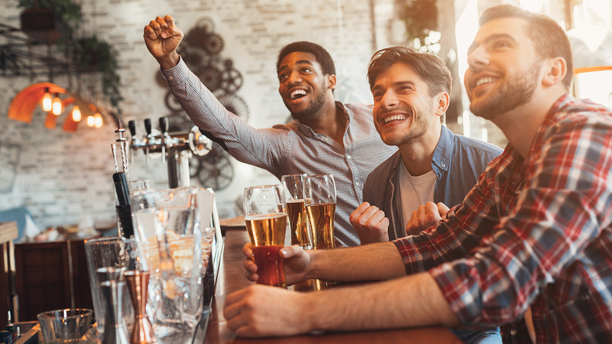 Men at bar watching TV