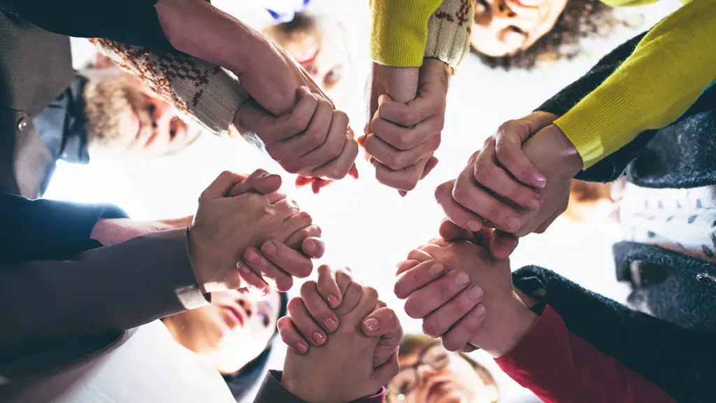 People who overcame grief holding each other by hands; symbolic of the support in the Coping with Loss online forum on Connection Communities.