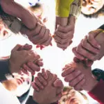 People who overcame grief holding each other by hands; symbolic of the support in the Coping with Loss online forum on Connection Communities.