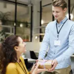 Photo of a young manager delivering a gift to her employee as part of their company's corporate gifting program