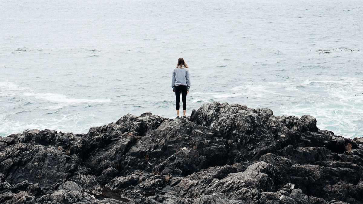 Photo of a woman standing on a rocky cliff