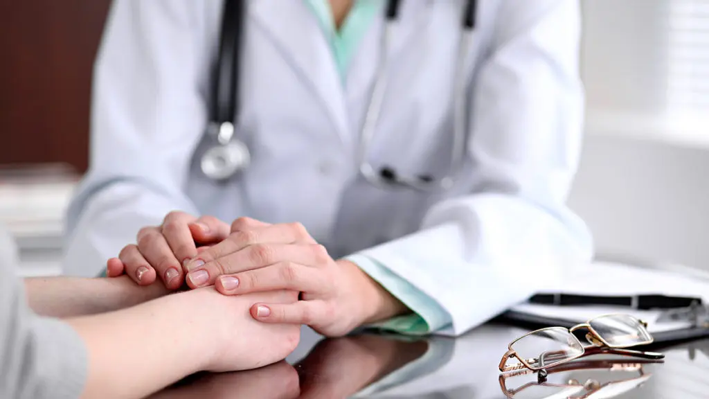 Photo of a doctor comforting a patient with a terminal illness