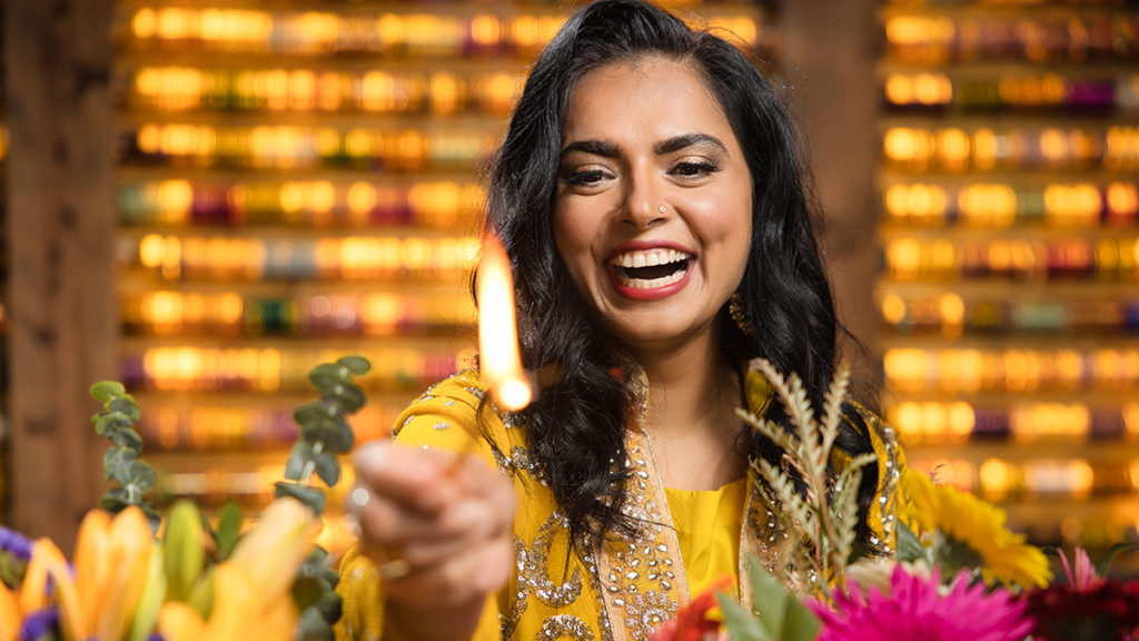 Photo of chef Maneet Chauhan lighting a candle as part of Diwali celebrations