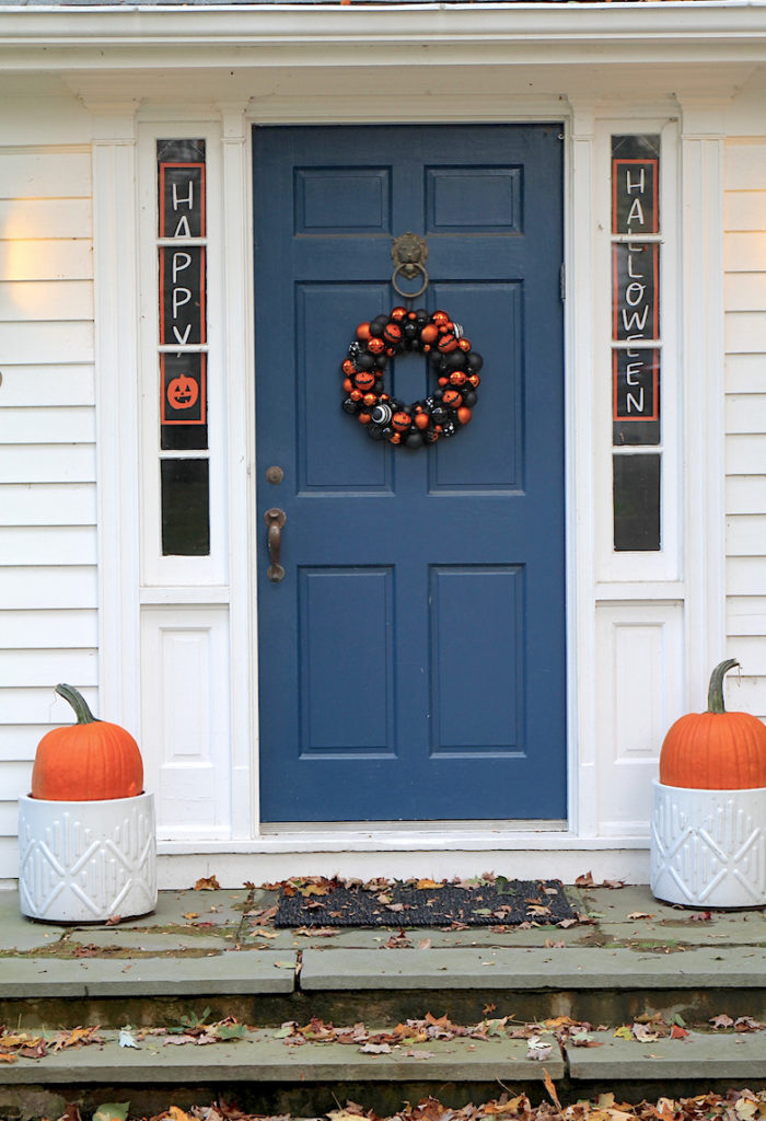 Picture of front porch with blue door and Halloween wreathfor fall