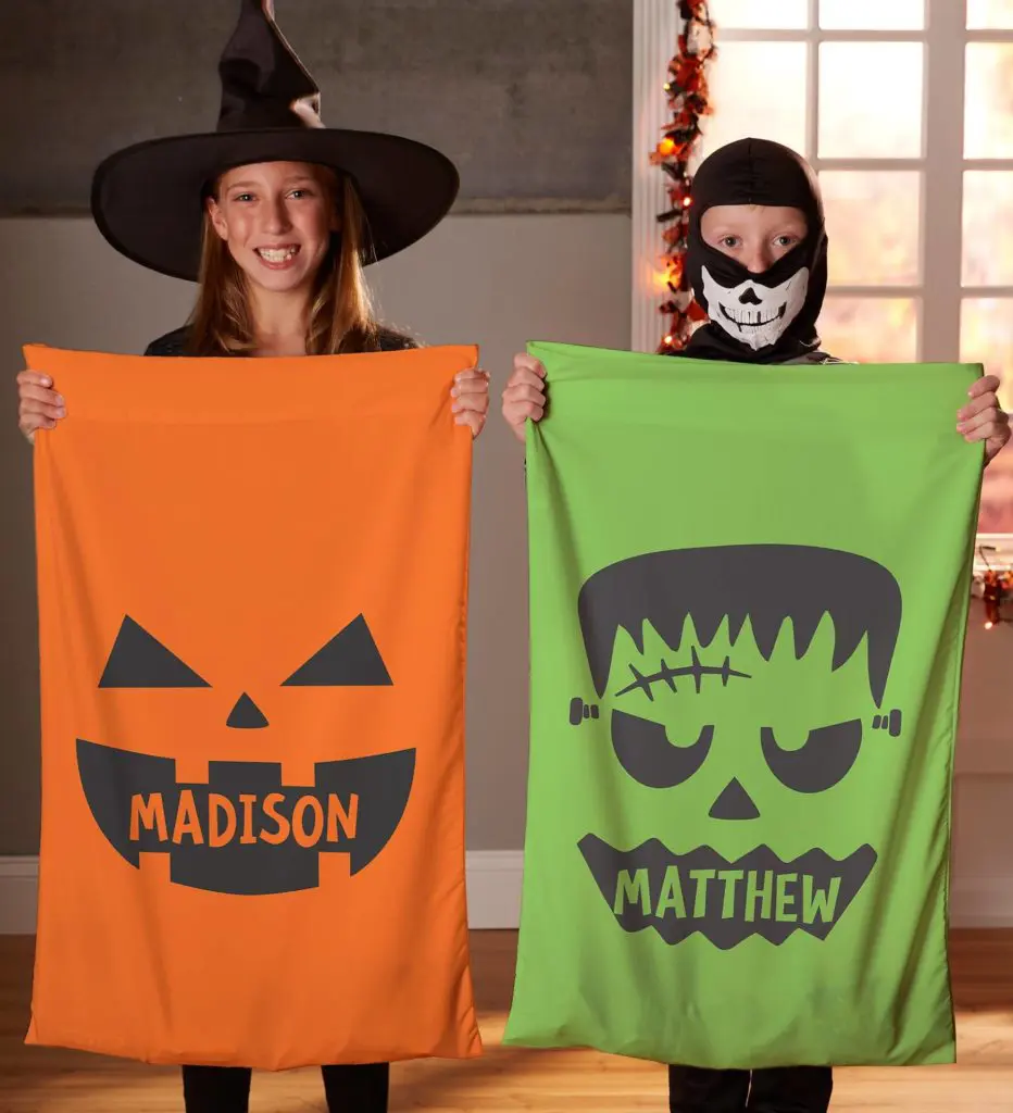 halloween decor ideas with two children holding personalized spooky pillow cases