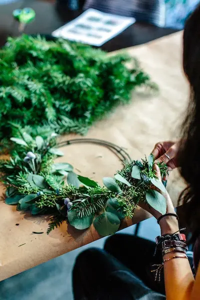 diy christmas wreath with woman making a wreath