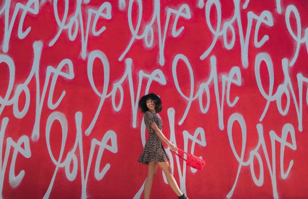 Picture of girl walking by love mural