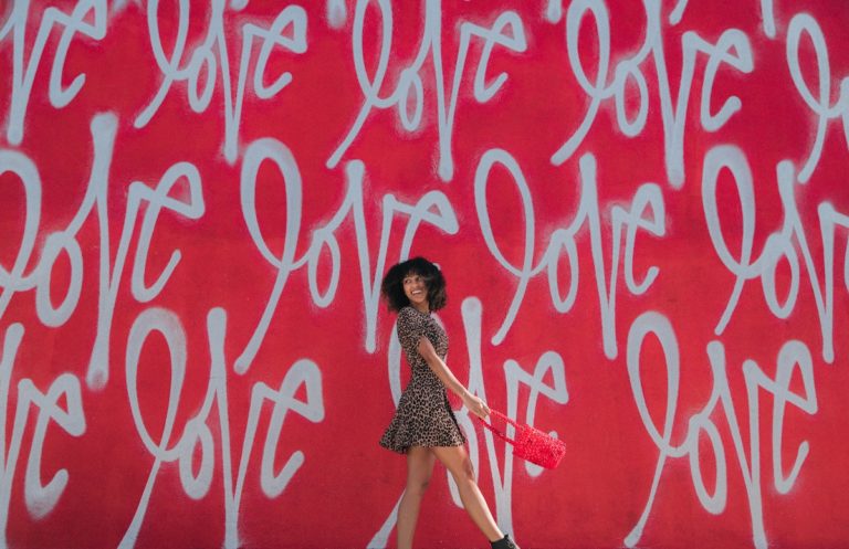 Picture of girl walking by love mural