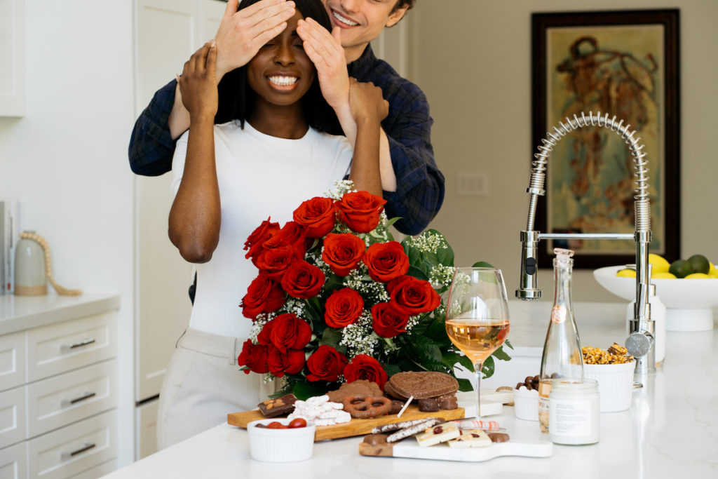 Photo of man surprising woman with roses