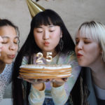 a photo of why every birthday is special: friends blowing out birthday candles