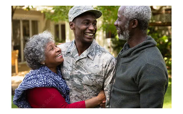 A photo of older parents welcoming their son home after a military tour.