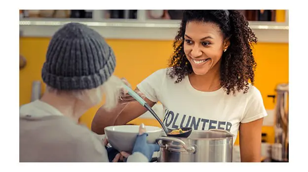 Photo of a caregiver sharing the gift of care by serving soup