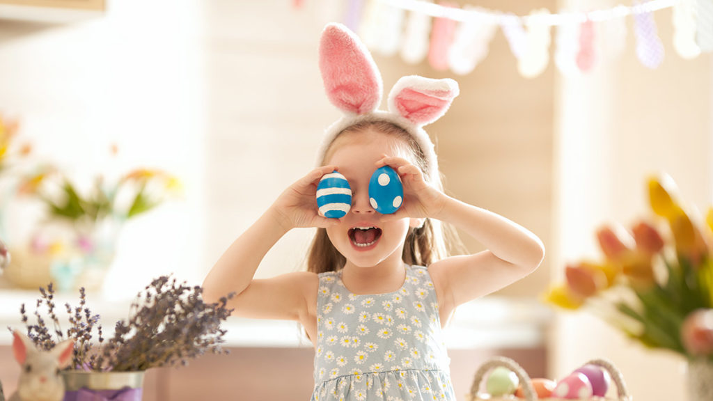 a photo of easter egg decorating ideas: girl playing with easter eggs