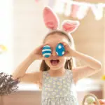 a photo of easter egg decorating ideas: girl playing with easter eggs