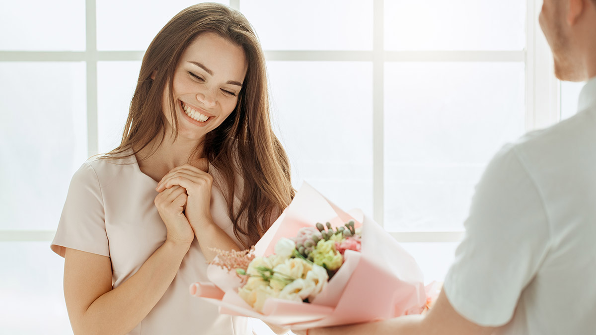 Persona para quien comprar es difícil: Mujer recibiendo flores