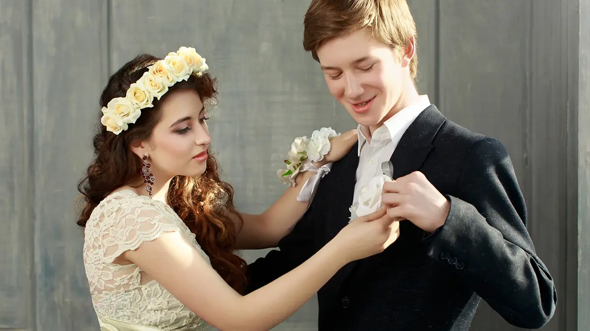 prom corsage with date pinning boutonniere on lapel