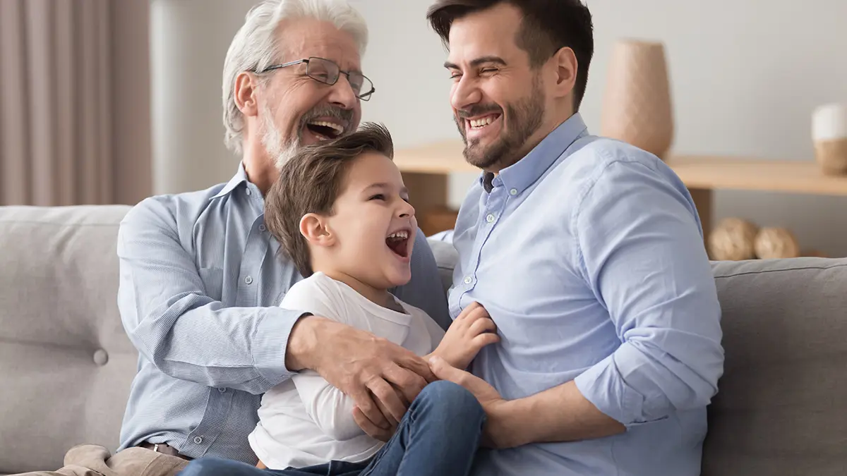 father's day ideas with a grandfather, son and grandson sitting on a couch and laughing