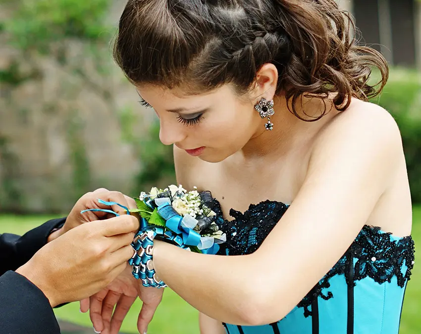 prom corsage with man tying a wrist corsage