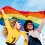 a photo of pride month gifts with two women holding a pride flag