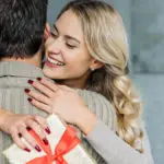 Photo of a woman receiving a gift from a man.