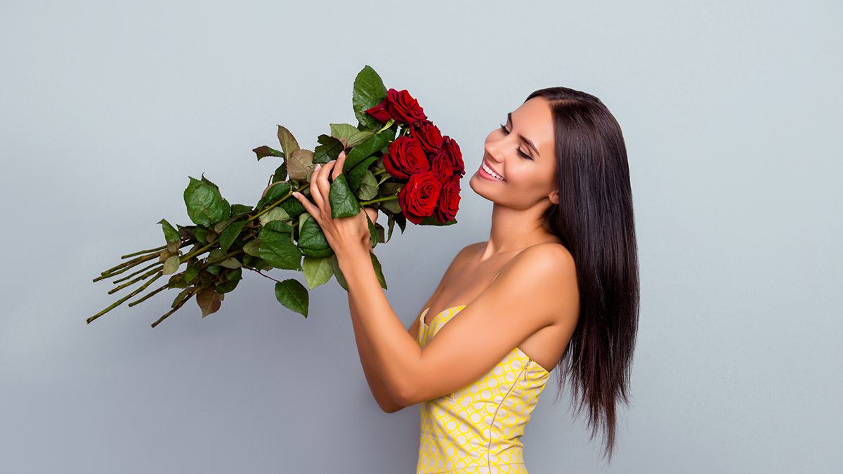 a photo of facts about roses with woman smelling roses