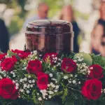 a photo of a cremation service with a funerary urn with ashes of dead and flowers at funeral