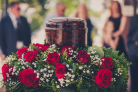 a photo of a cremation service with a funerary urn with ashes of dead and flowers at funeral