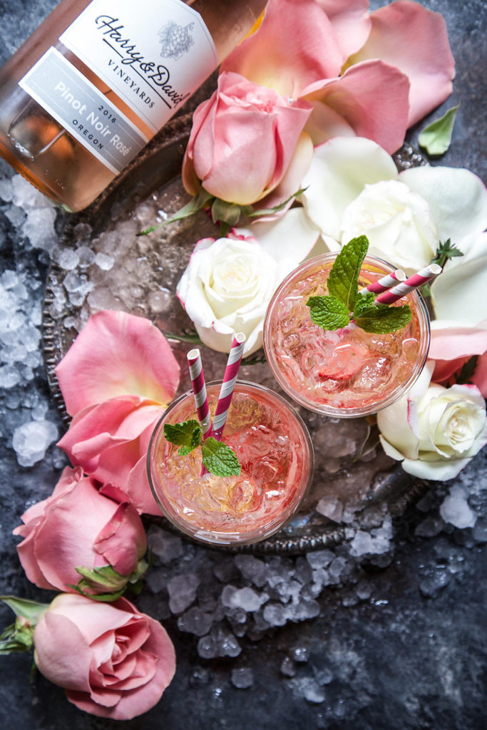 a photo of Rosé Cocktail with a bottle of wine and pink and white roses