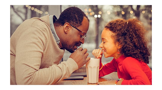 Father and daughter enjoy a milkshake on Father's Day