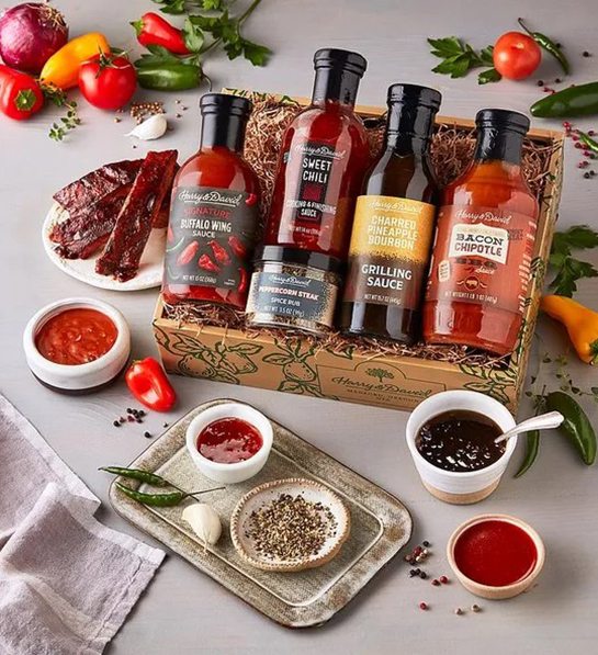 Una foto de ideas de regalos para el Día del Padre con una caja de salsas BBQ rodeada de pequeños moldes de las salsas.