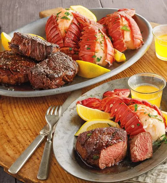 A photo of father's day gift ideas with two plates of cooked steak and lobster