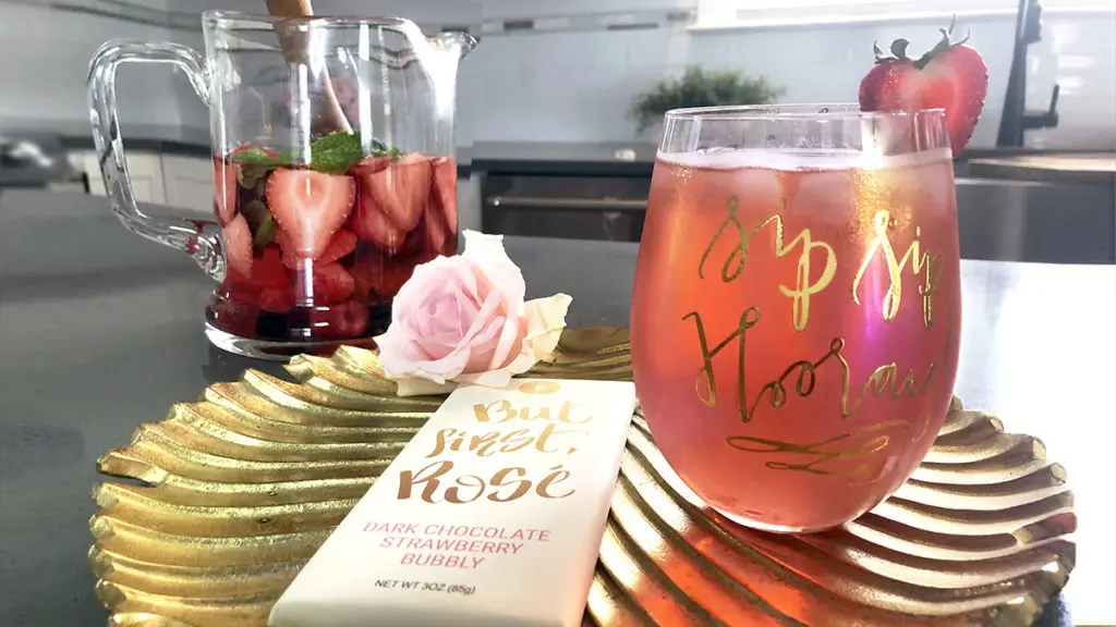 Photo of rosé sangria mojito cocktail in a glass with a chocolate bar