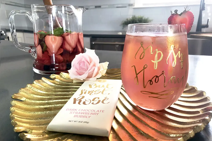 Photo of rosé sangria mojito cocktail in a glass with a chocolate bar