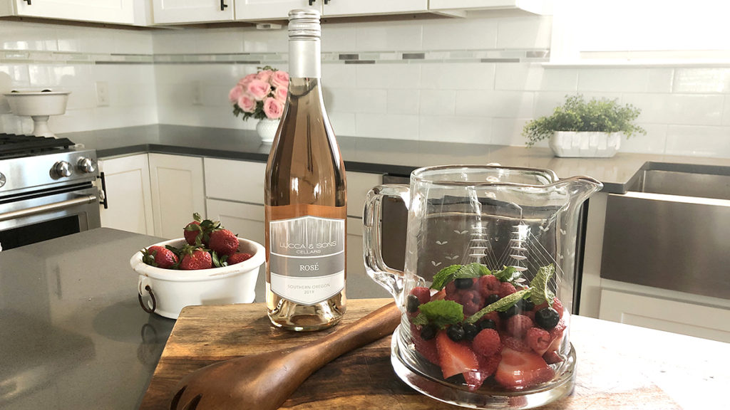 Photo of rosé sangria with a bottle of rosé and a pitcher of fruit